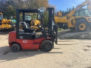 Red EP Equipment 25 Lion forklift parked on a construction site with machinery in the background.